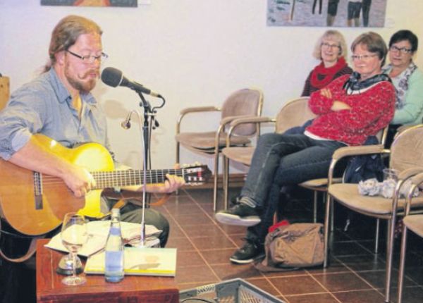 „Cold Reading“ im Museumsstübchen: Maiko Müller (links) aus Kassel las oder vertonte mit seiner Gitarre, was die Zuhörer mitgebracht hatten, vom Kinderbuch bis zur Zeitungsanzeige. Foto: Porath